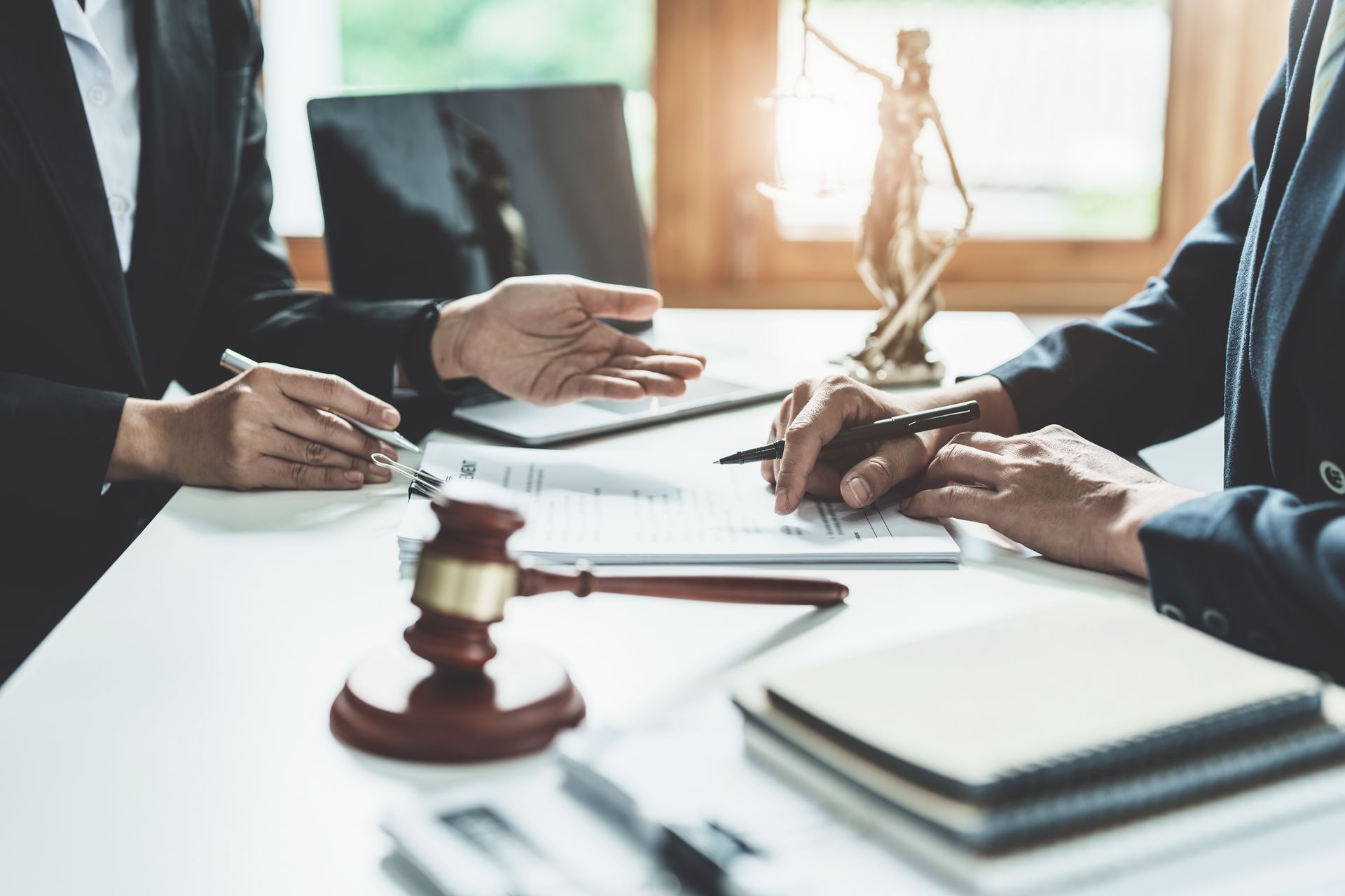The defense lawyer consults the client with justice symbols on the desk. The defense lawyer consults the client with justice symbols on the desk.
