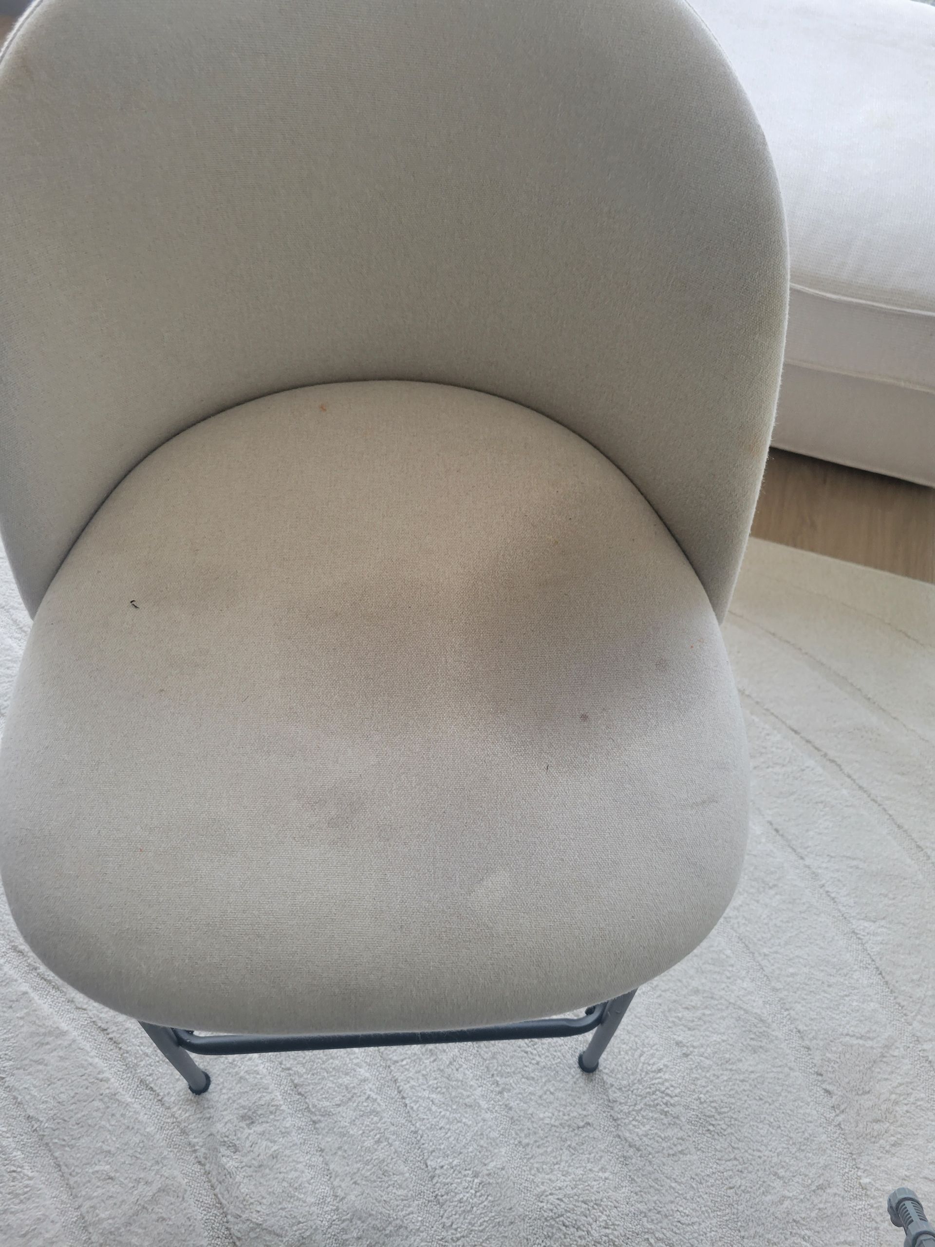 A white chair is sitting on a white rug in a living room.