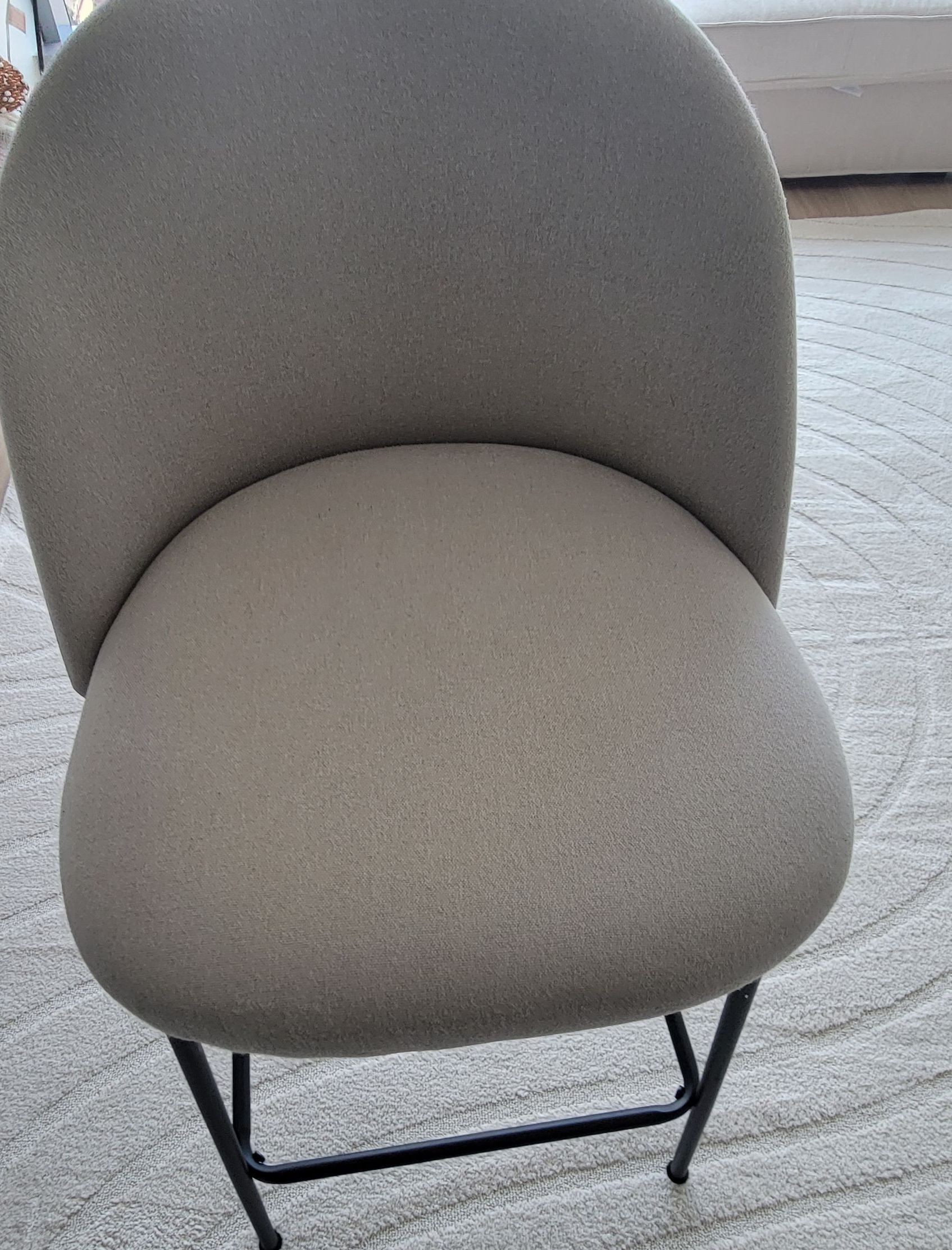 A chair is sitting on a white rug in a living room.