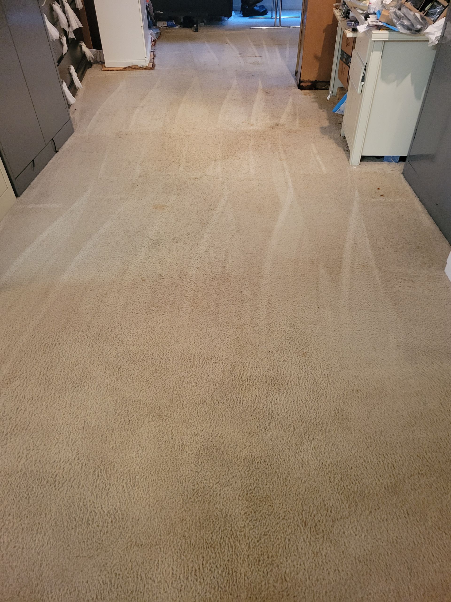 A room with a carpeted floor and a dresser in it.