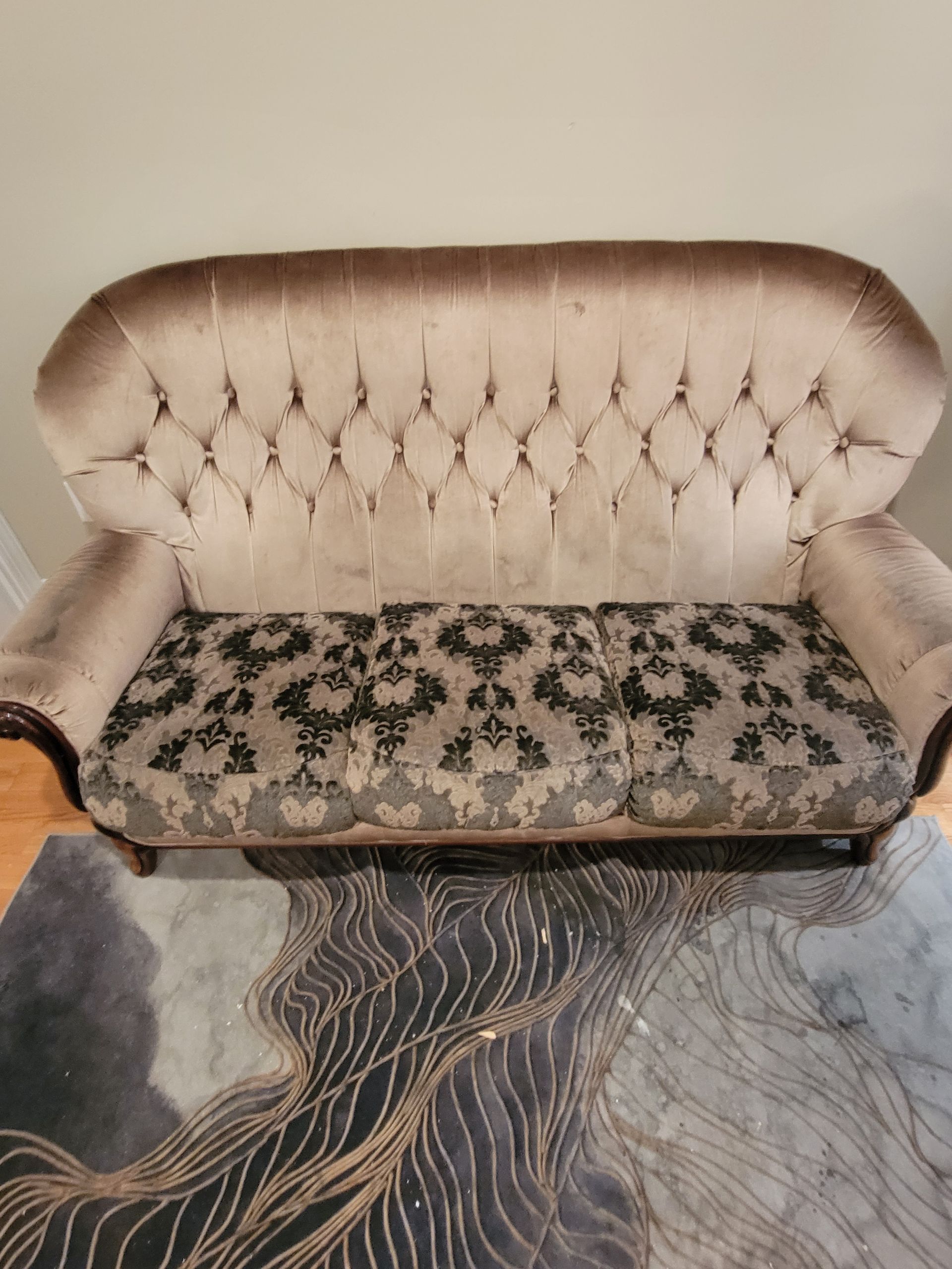 A couch is sitting on top of a rug in a living room.