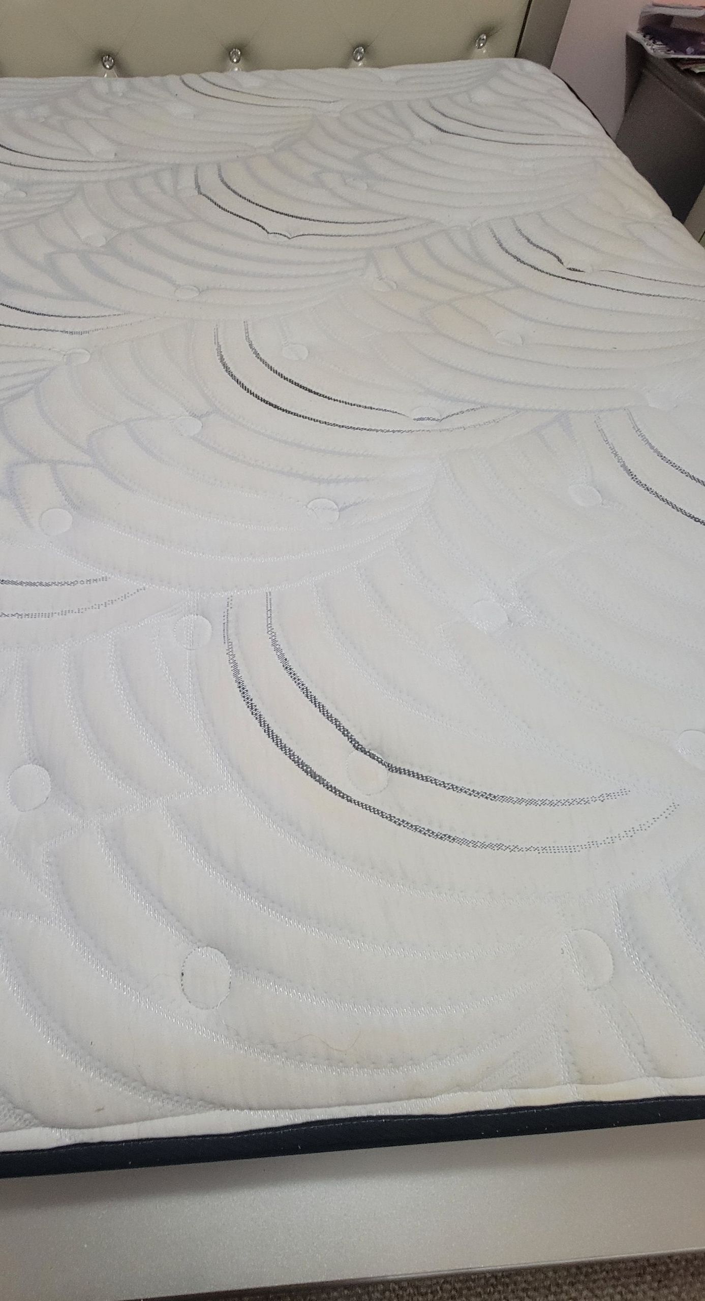 A white mattress is sitting on top of a bed.
