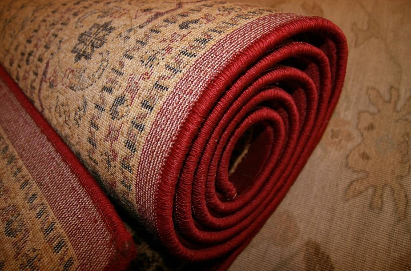 A close up of a rolled up rug with a red border