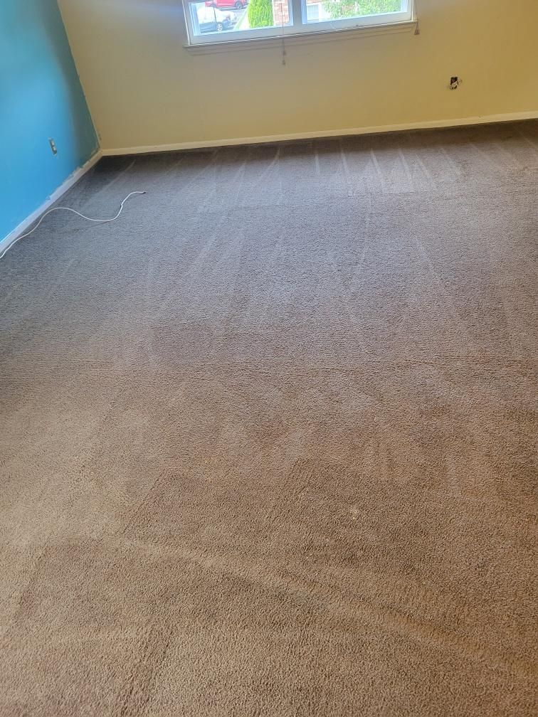 A living room with a large carpeted floor and a window.