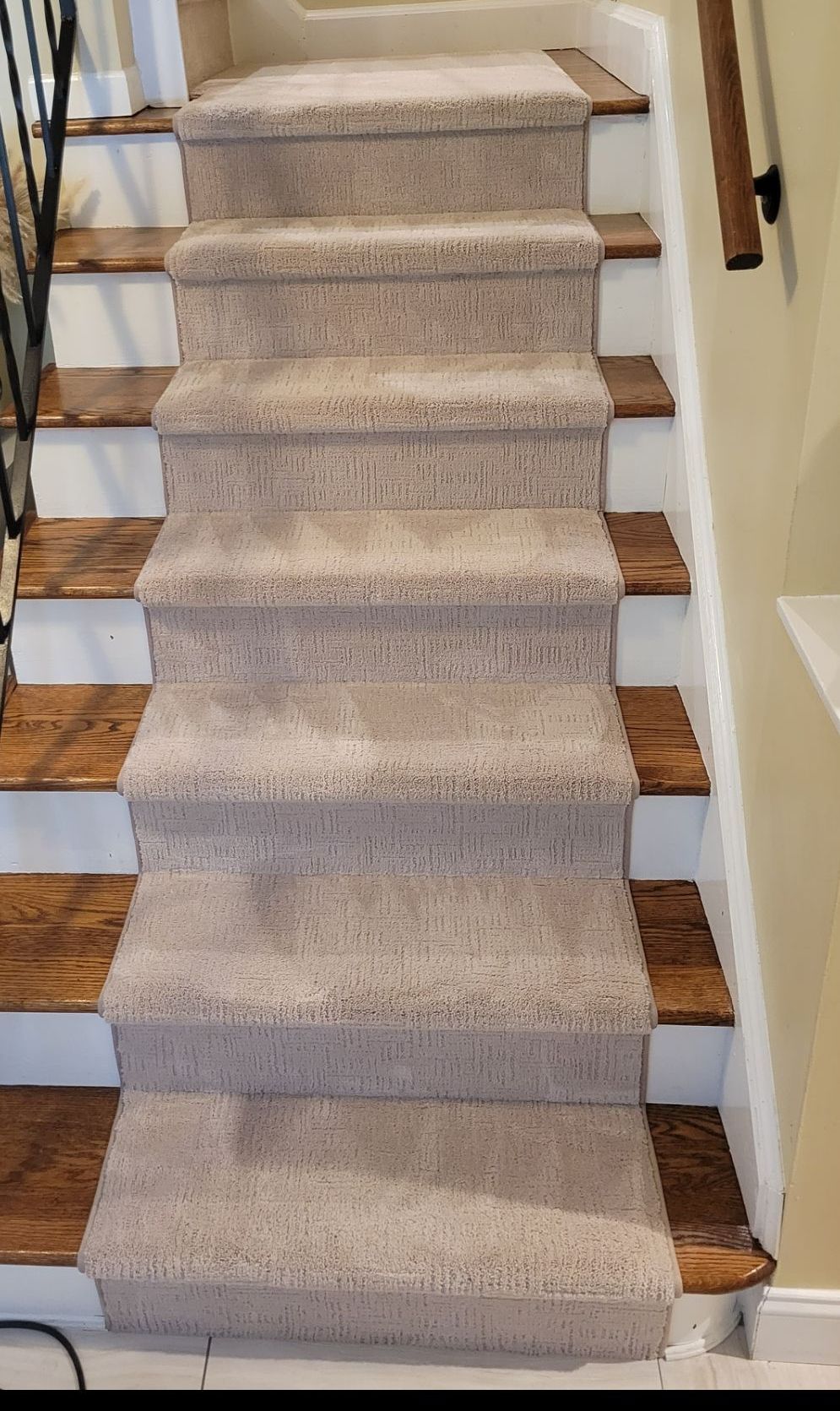 A staircase with a carpeted staircase and wooden steps.