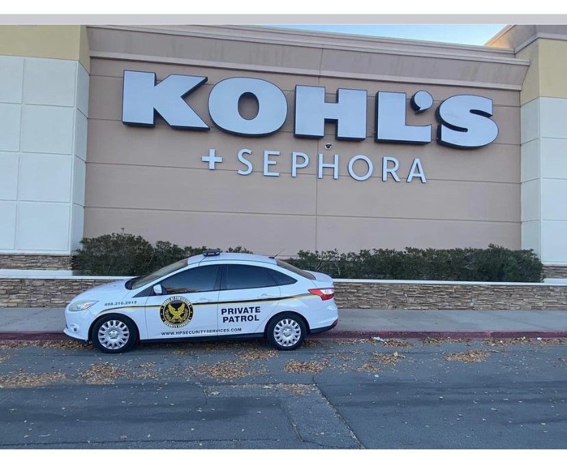 White “Private Patrol” car parked outside a Kohl’s + Sephora store.