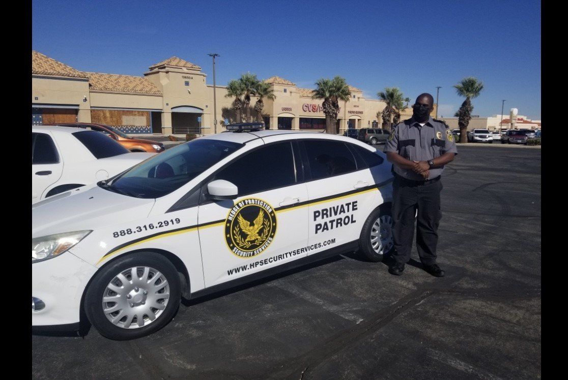 Border Patrol vehicle parked in a lot with an officer standing beside it under a clear sky