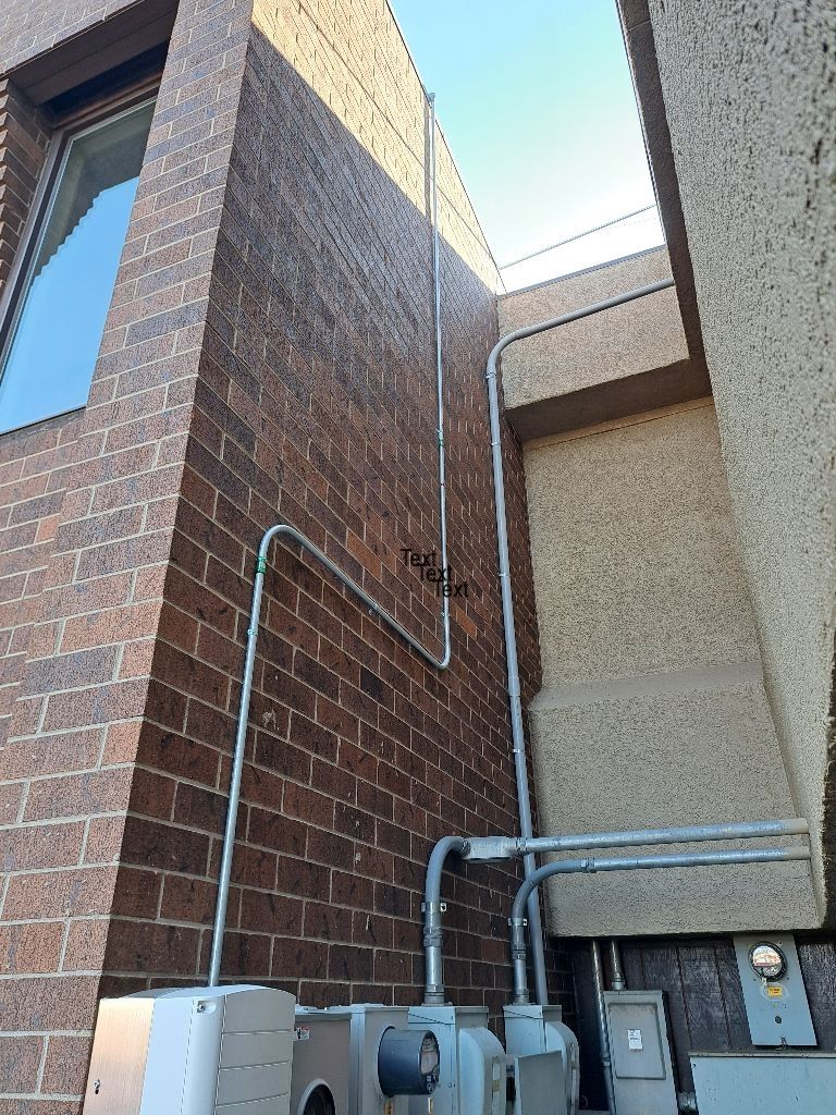 A brick building with a lot of wires coming out of it.