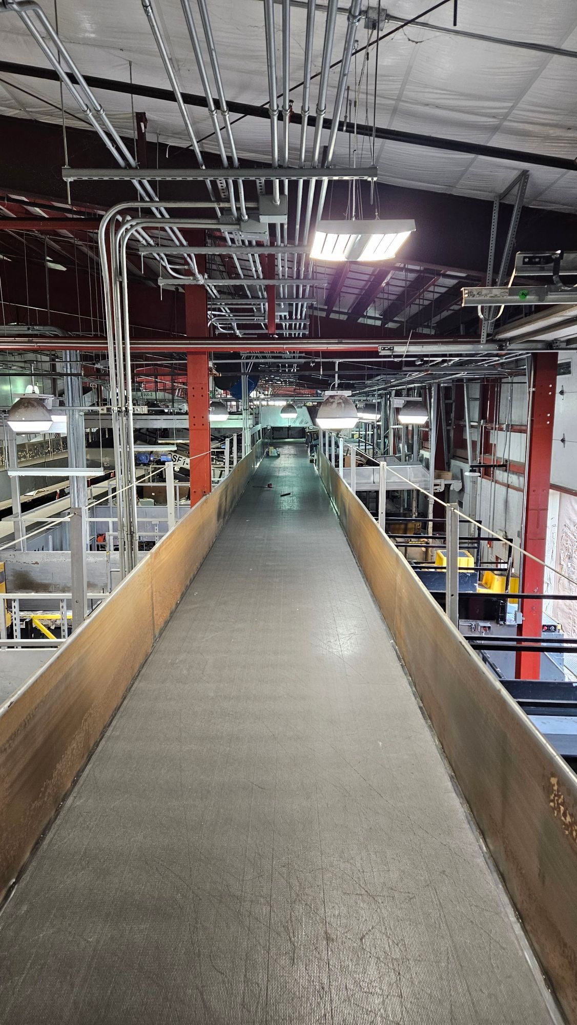 A long conveyor belt is going through a large building.