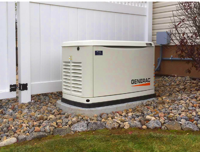 A generac generator is sitting next to a white fence