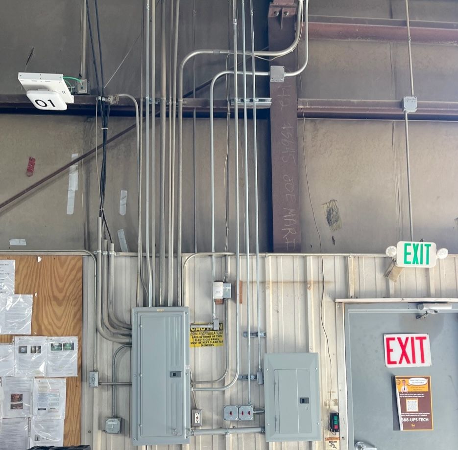 An exit sign hangs from the ceiling of a building