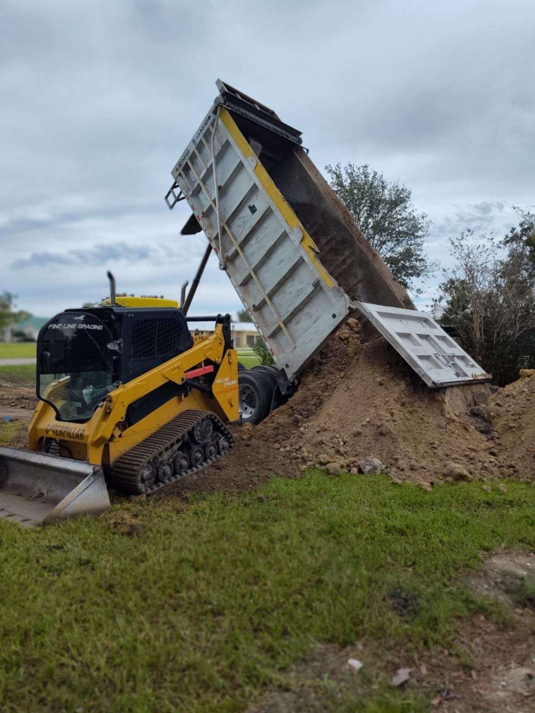 Construction site prep with heavy machinery for lot cleanup.