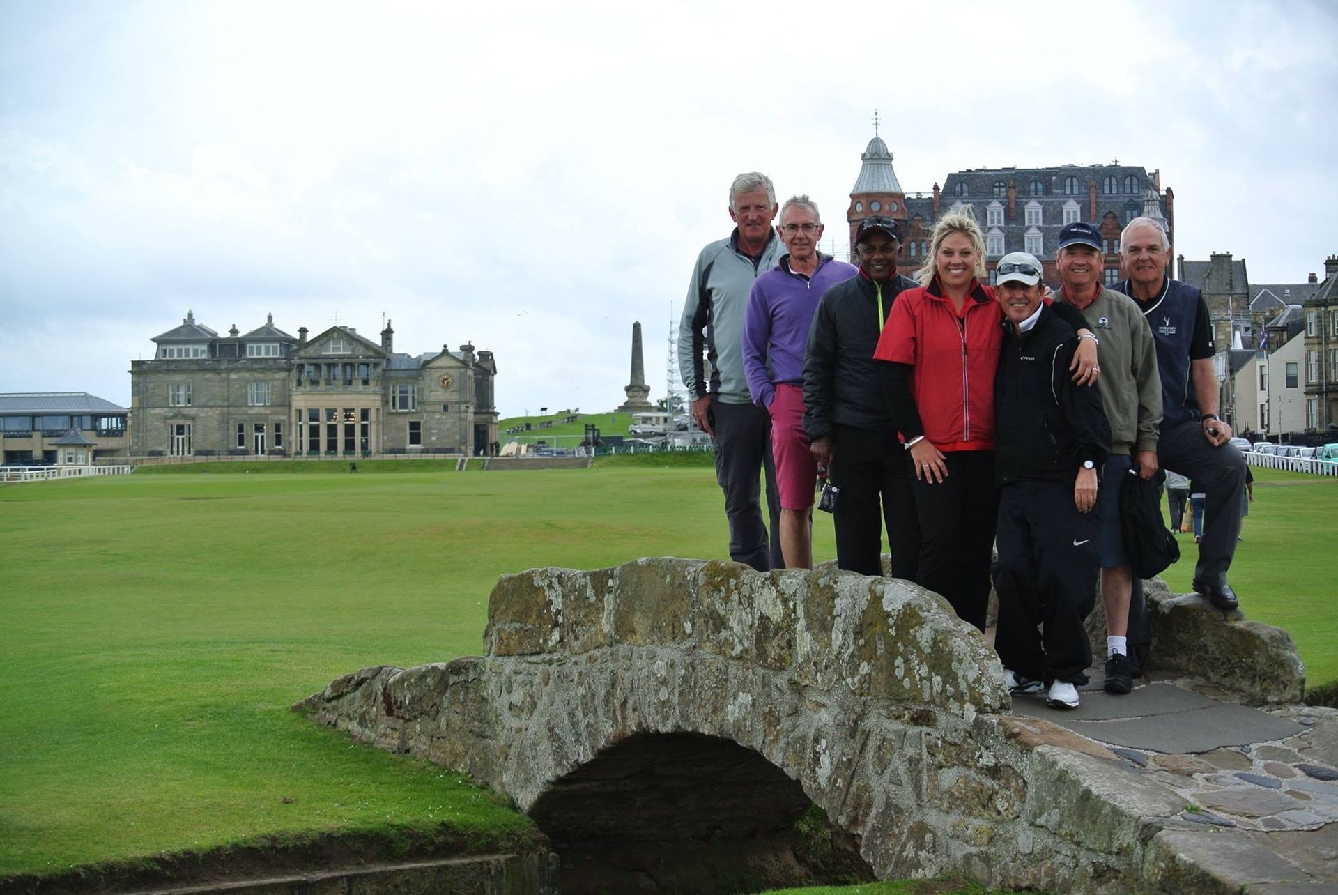 private golf group standing on bridge at st andrews scotland