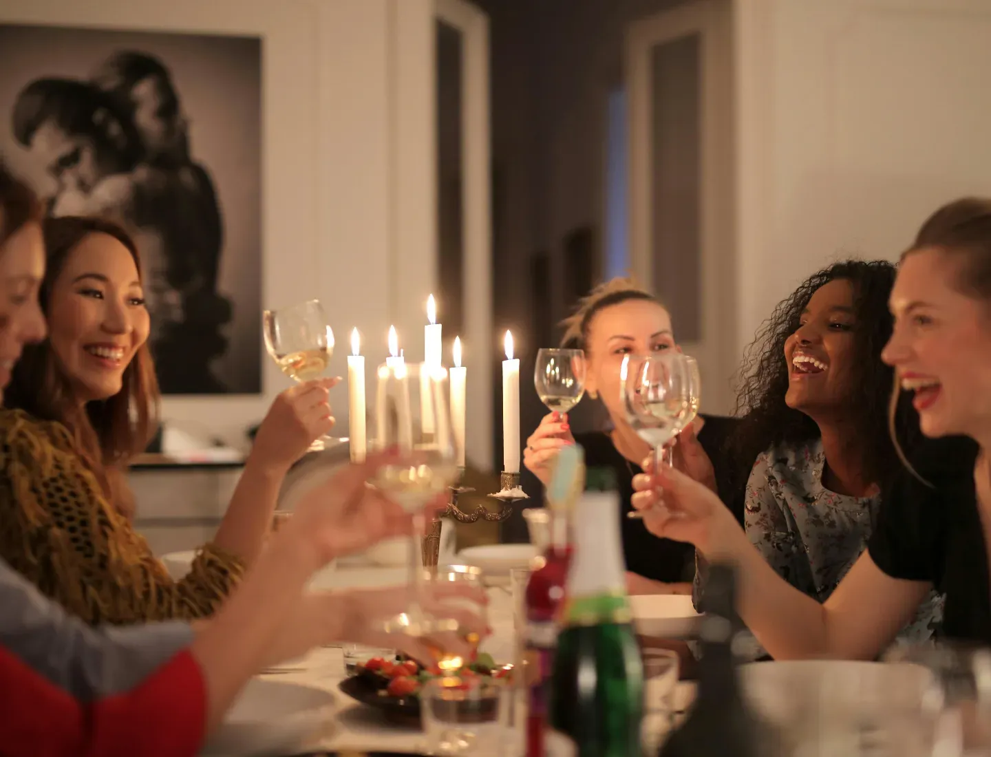 golfers toasting with wine glasses around a candlelit dinner table at a warm indoor gathering on final night of golf tour