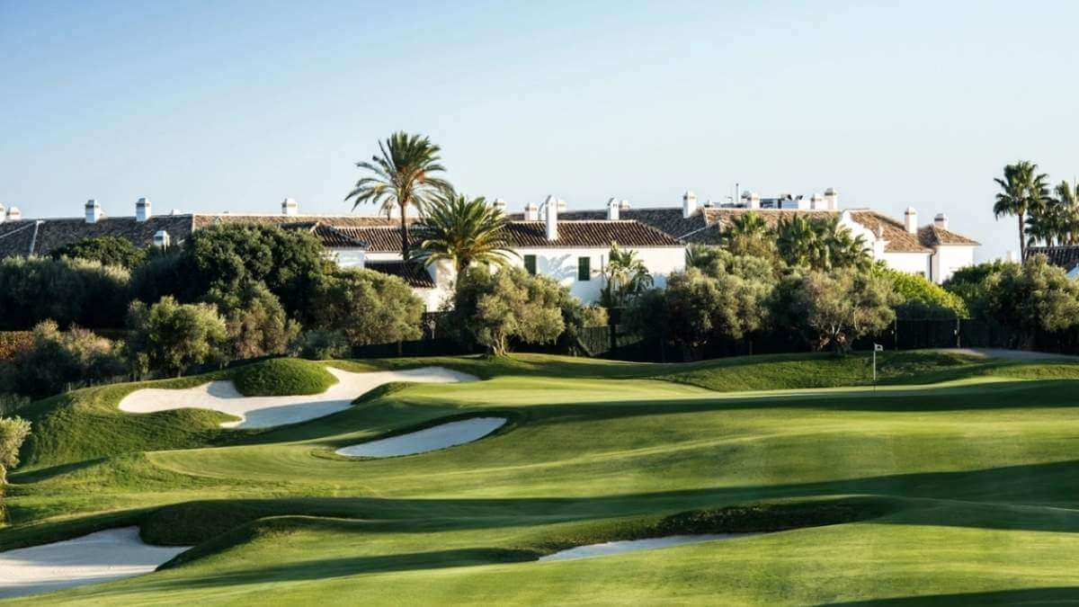 Sunlit golf course with green fairways, sand bunkers, at Finca cortesin golf club spain