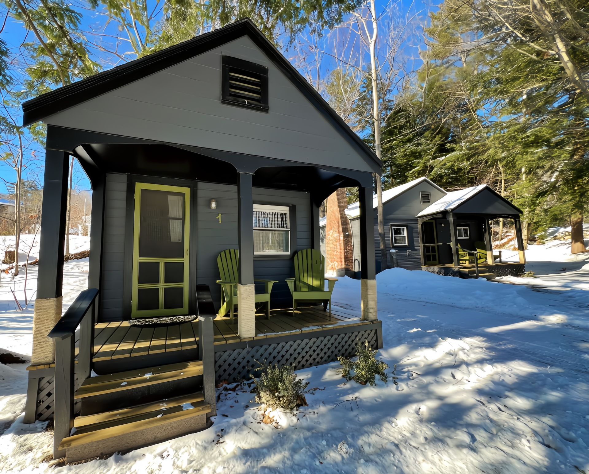 Small cabins with  porches and chairs in the snow