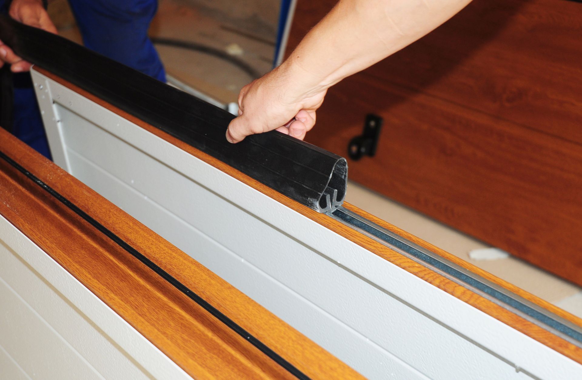 Hand installing a black handle on a white blind or window shade track