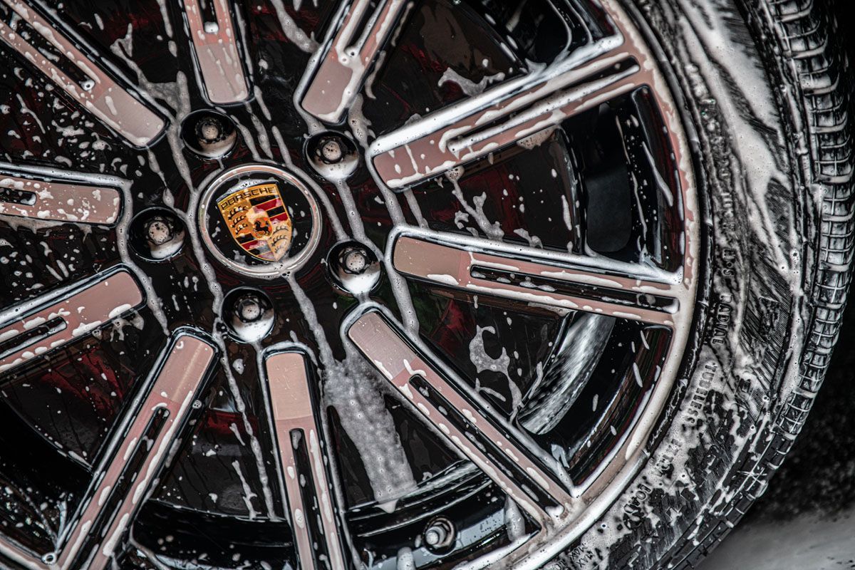 Porsche wheel being washed with soapy water.
