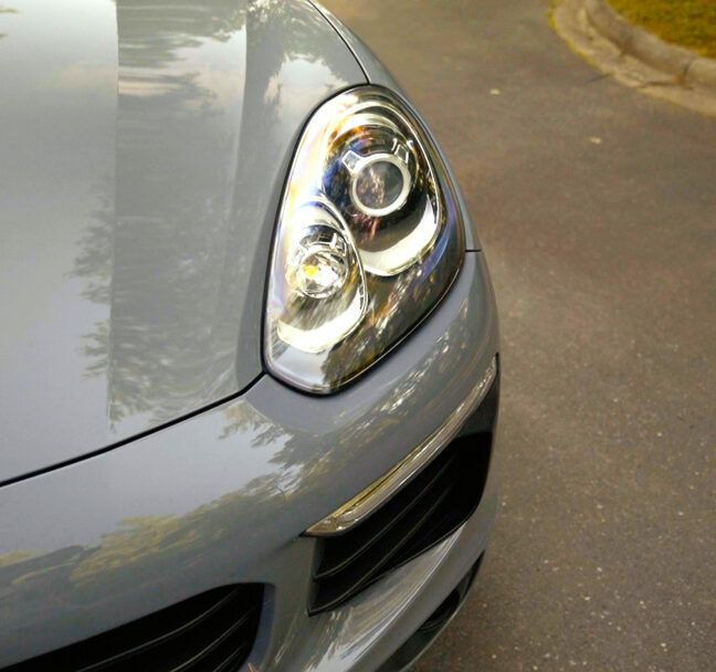 A close up of a car headlight on a road