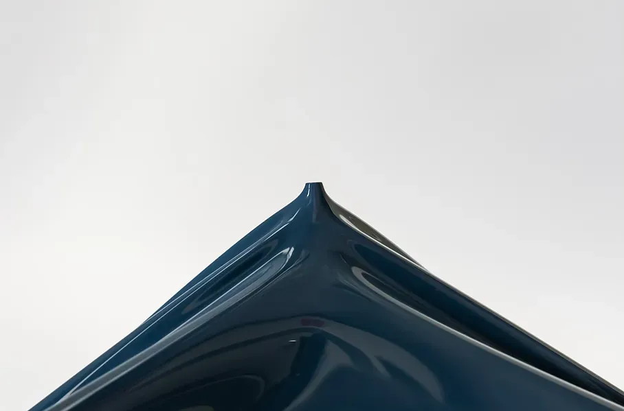 A close up of a blue triangle on a white background