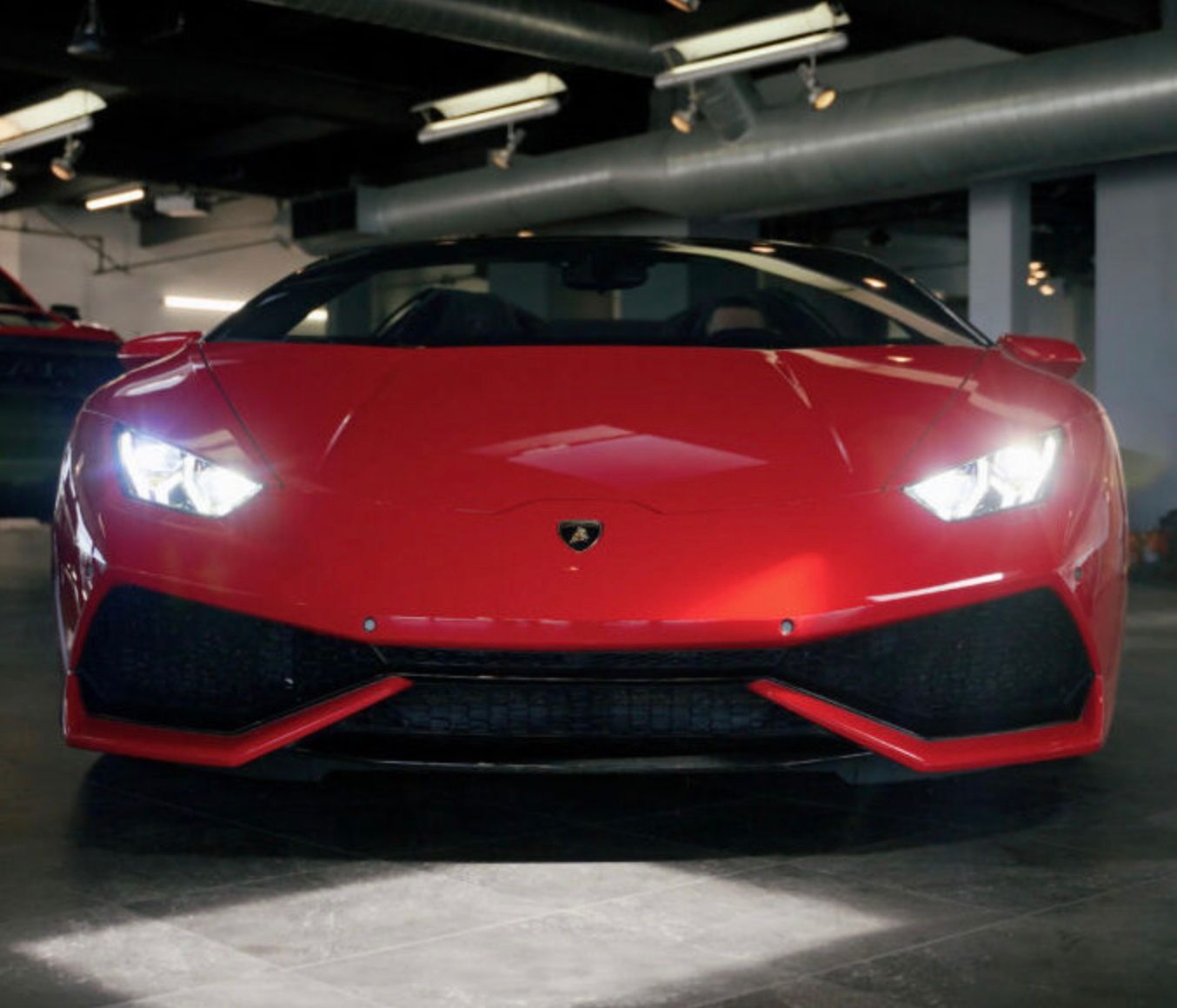 A red sports car is parked in a garage