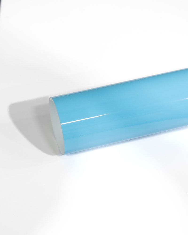 A light blue plastic tube is sitting on a white surface.