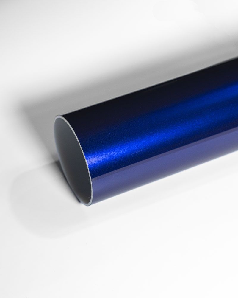 A close up of a blue pipe on a white surface.
