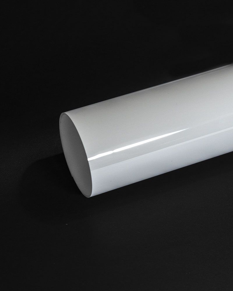 A white pipe is sitting on a black surface.