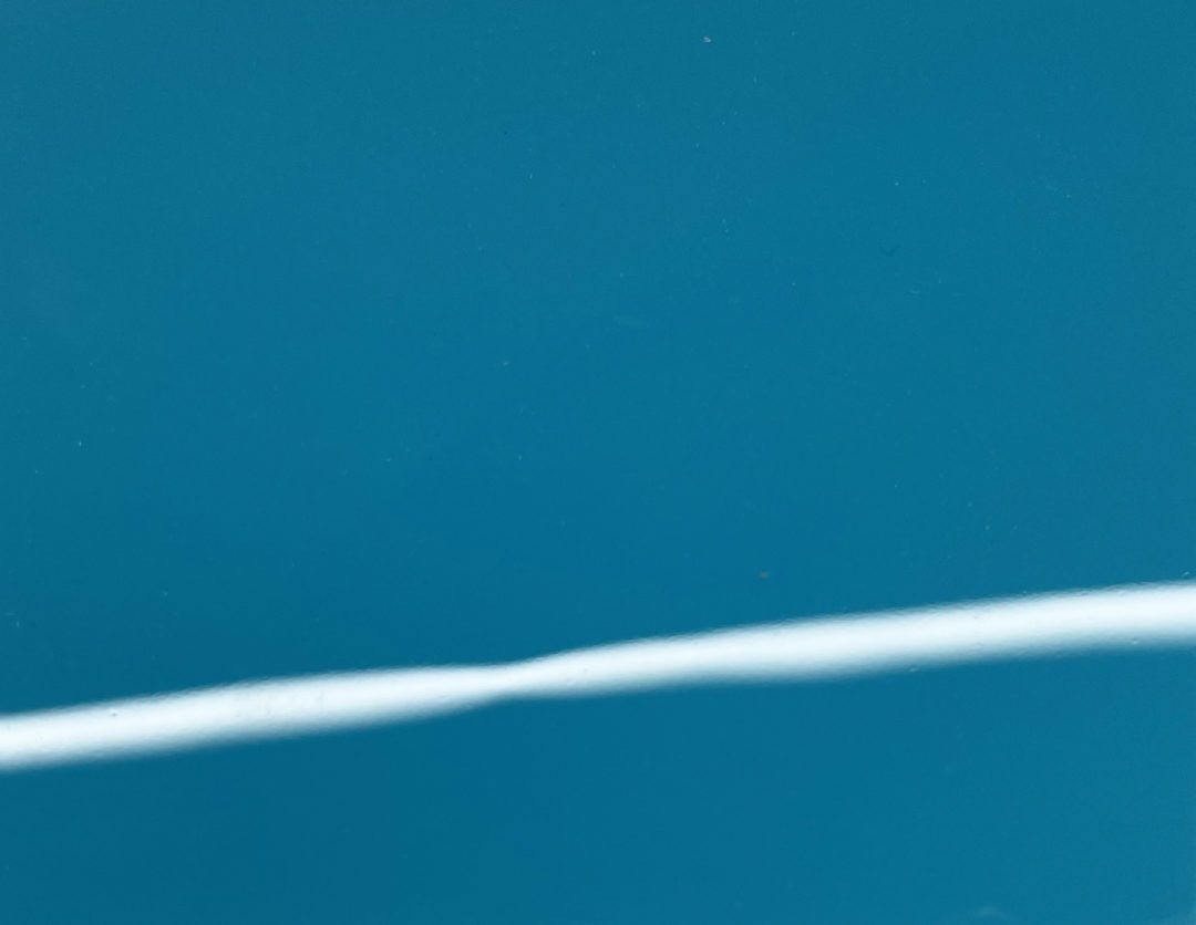 A close up of a blue surface with a white line on it.