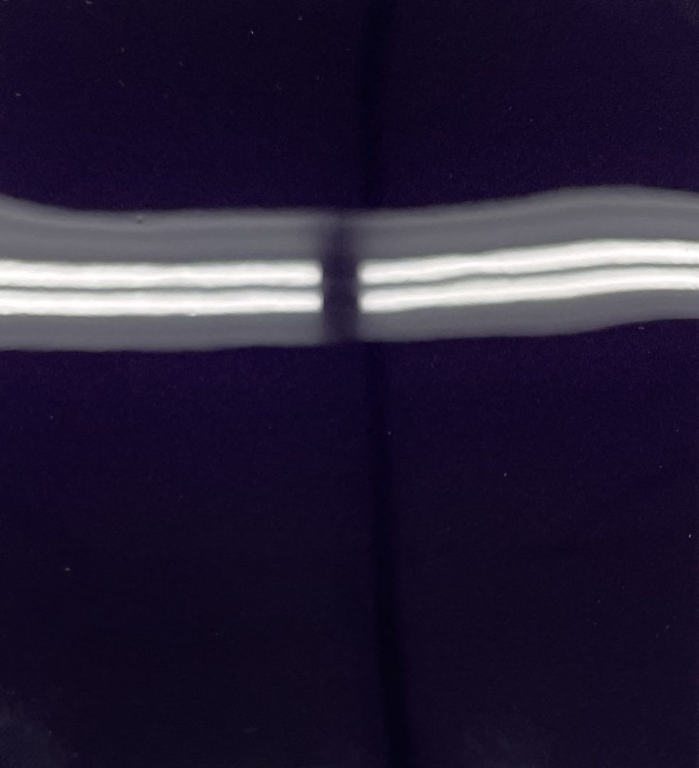 A close up of a pair of purple pants with white stripes on the side.