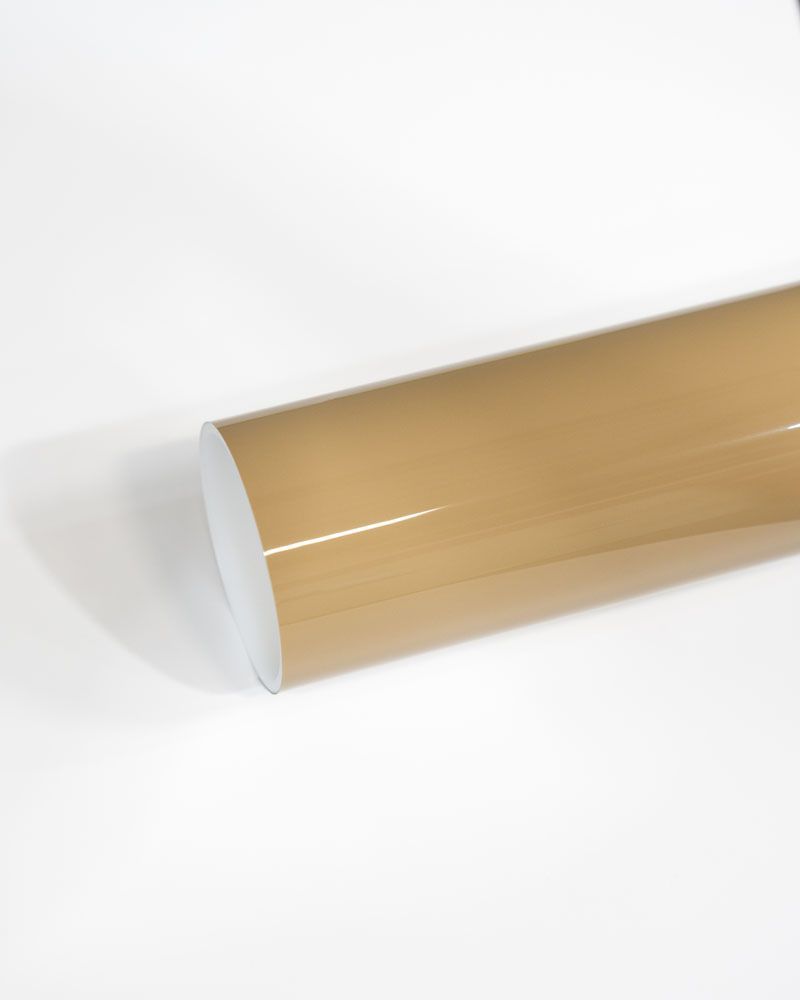 A roll of brown vinyl wrap is sitting on a white surface.