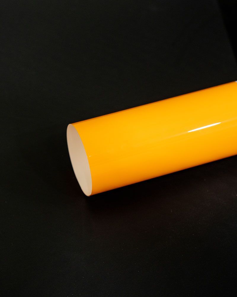 A close up of a yellow tube on a black surface.
