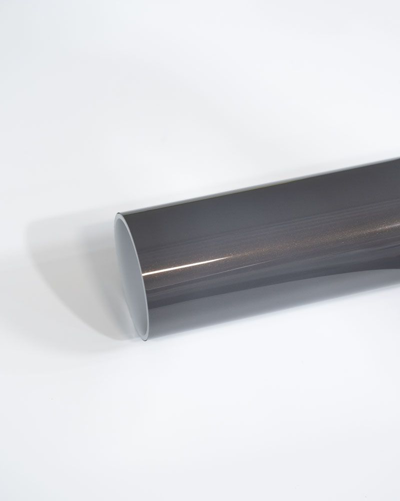 A close up of a gray pipe on a white surface.