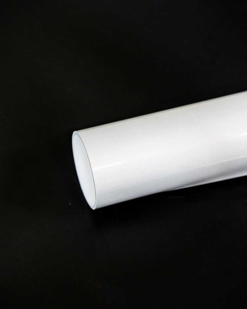 A white pipe is sitting on a black surface.