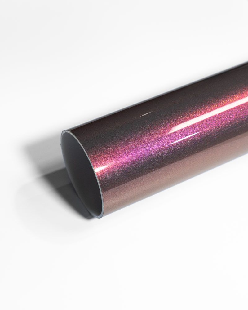 A close up of a purple metal pipe on a white surface.