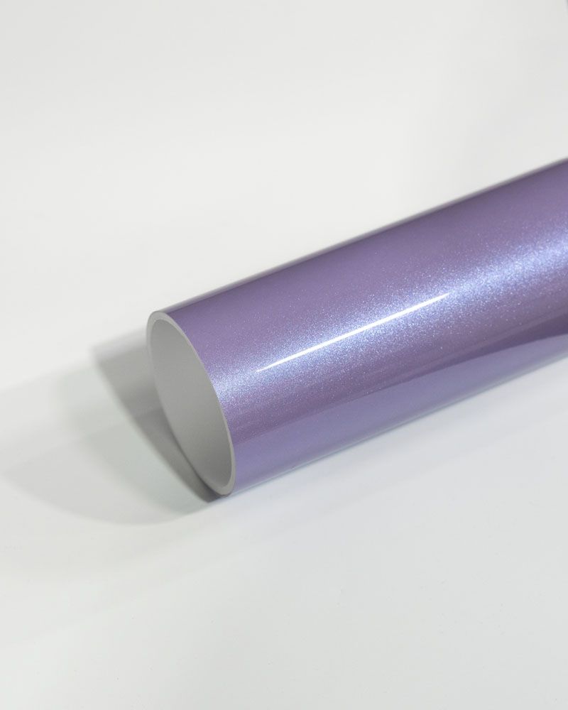A roll of purple vinyl wrap is sitting on a white surface.
