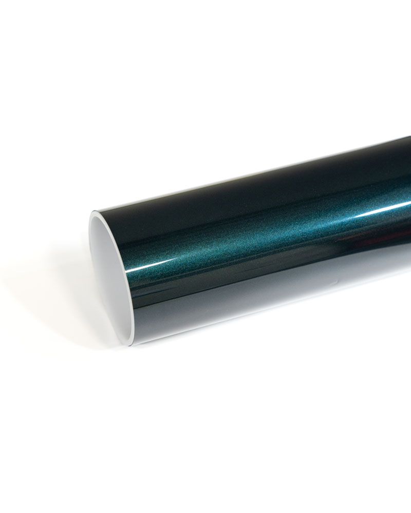 A close up of a roll of green vinyl wrap on a white surface.