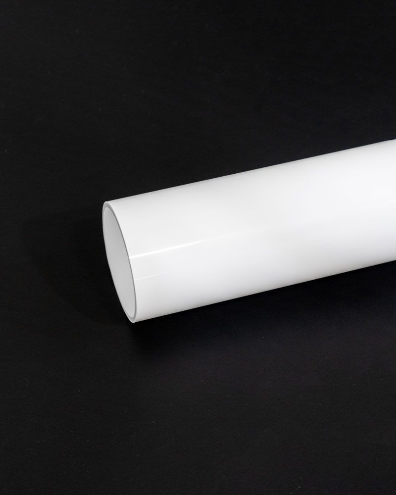 A white pipe is sitting on a black surface.