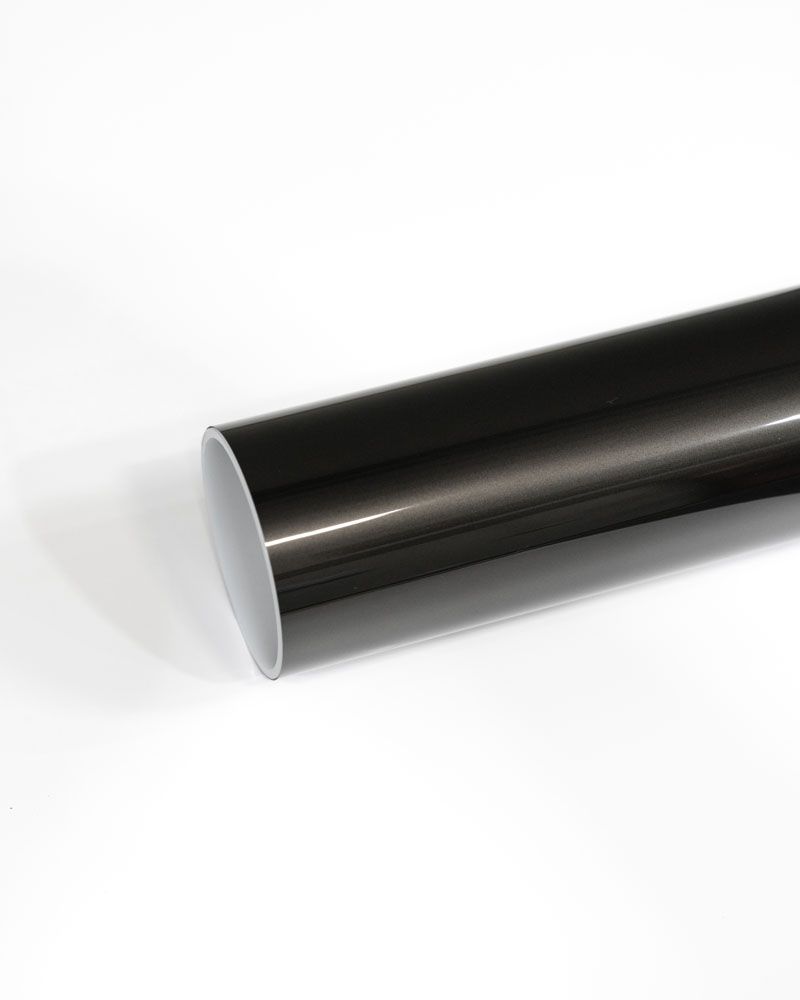 A roll of black vinyl wrap is sitting on a white surface.