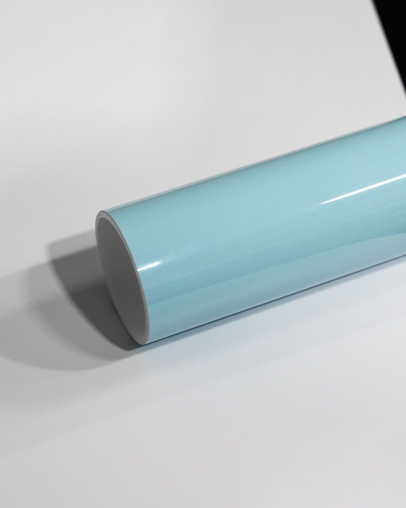 A light blue cylinder is sitting on a white surface.