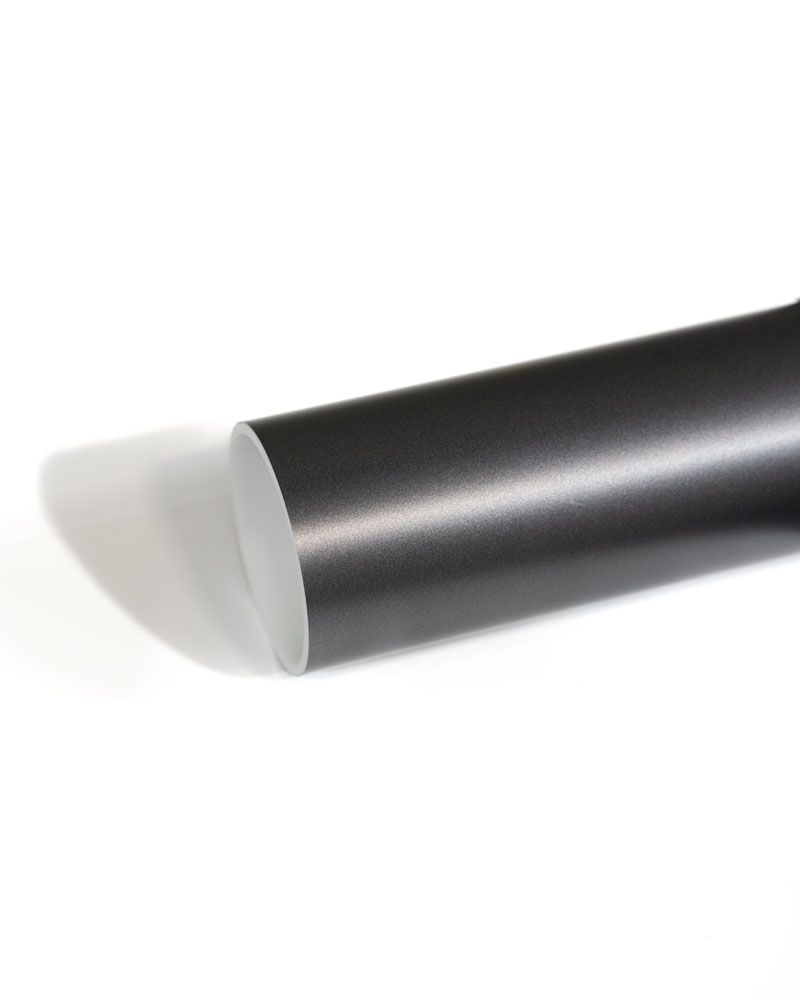 A close up of a black metal rod on a white surface.