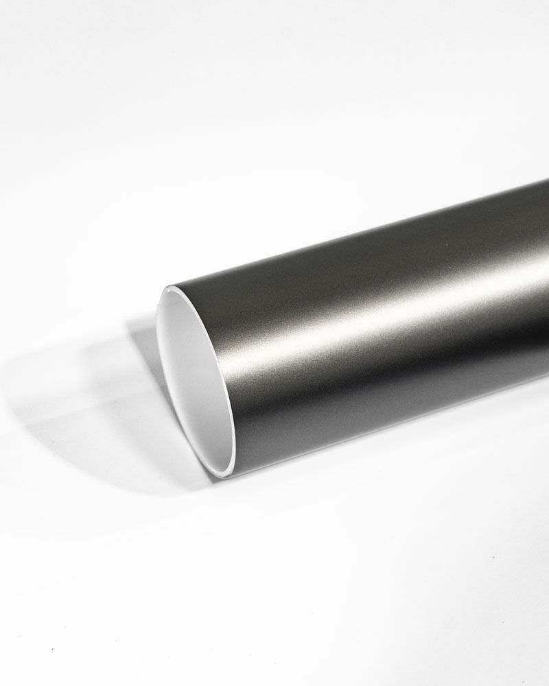 A close up of a metal pipe on a white surface.