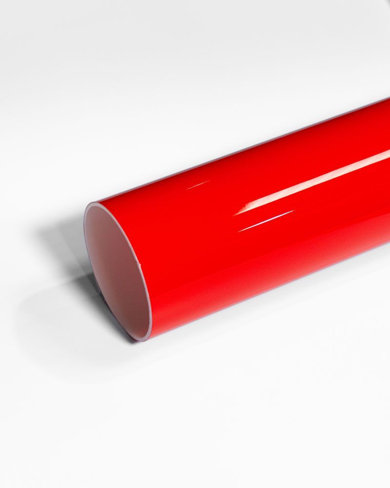 A close up of a red tube on a white surface.