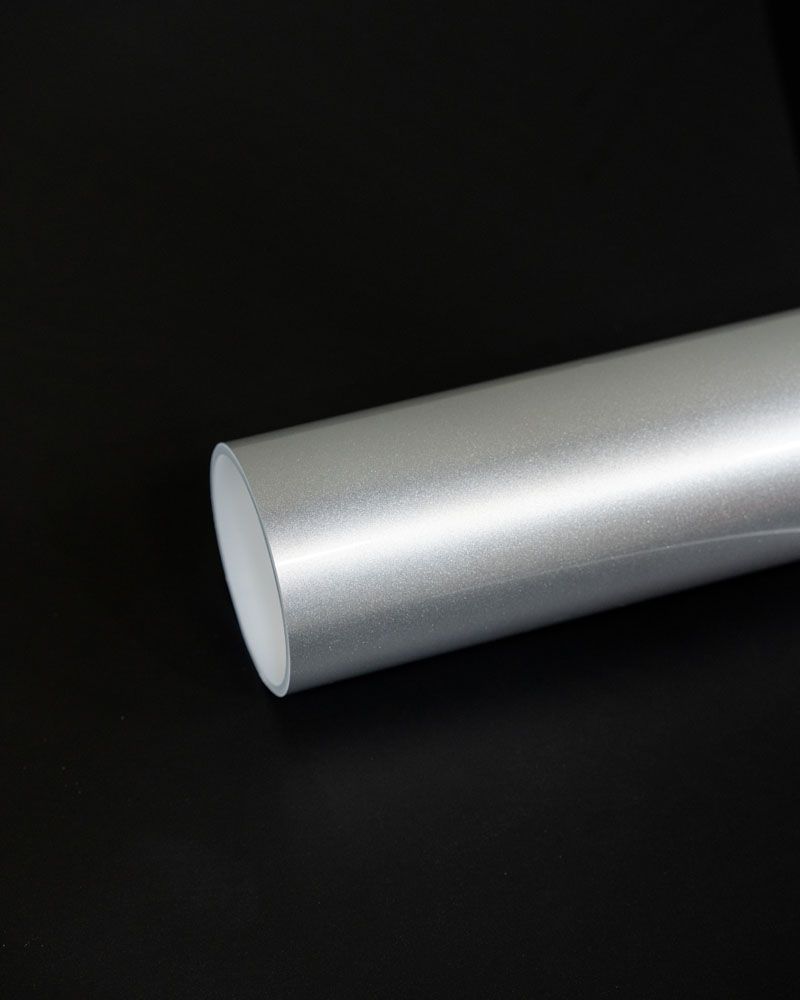 A close up of a silver pipe on a black surface.