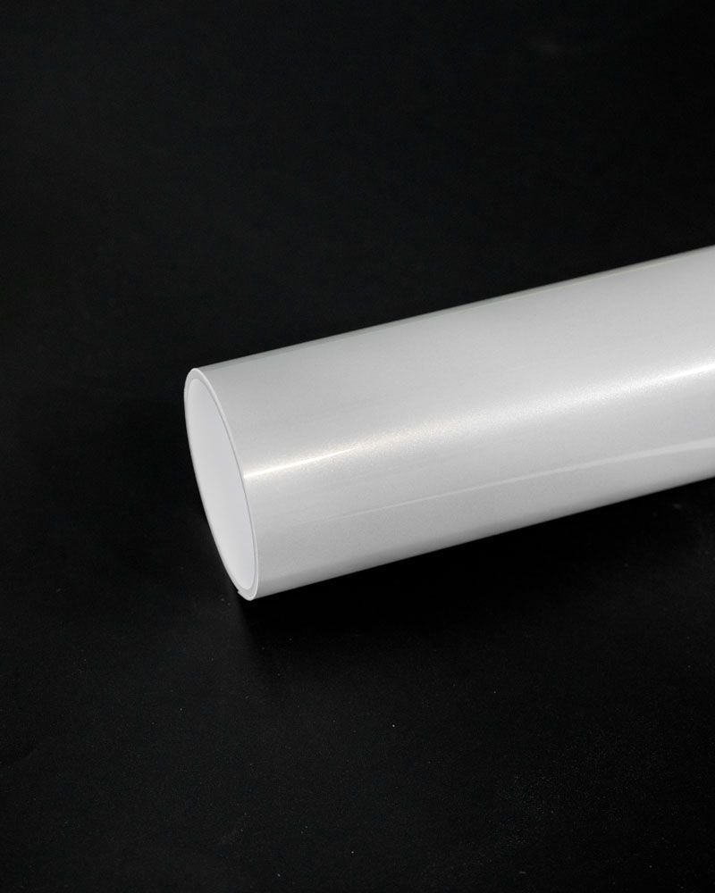 A white plastic tube is sitting on a black surface.
