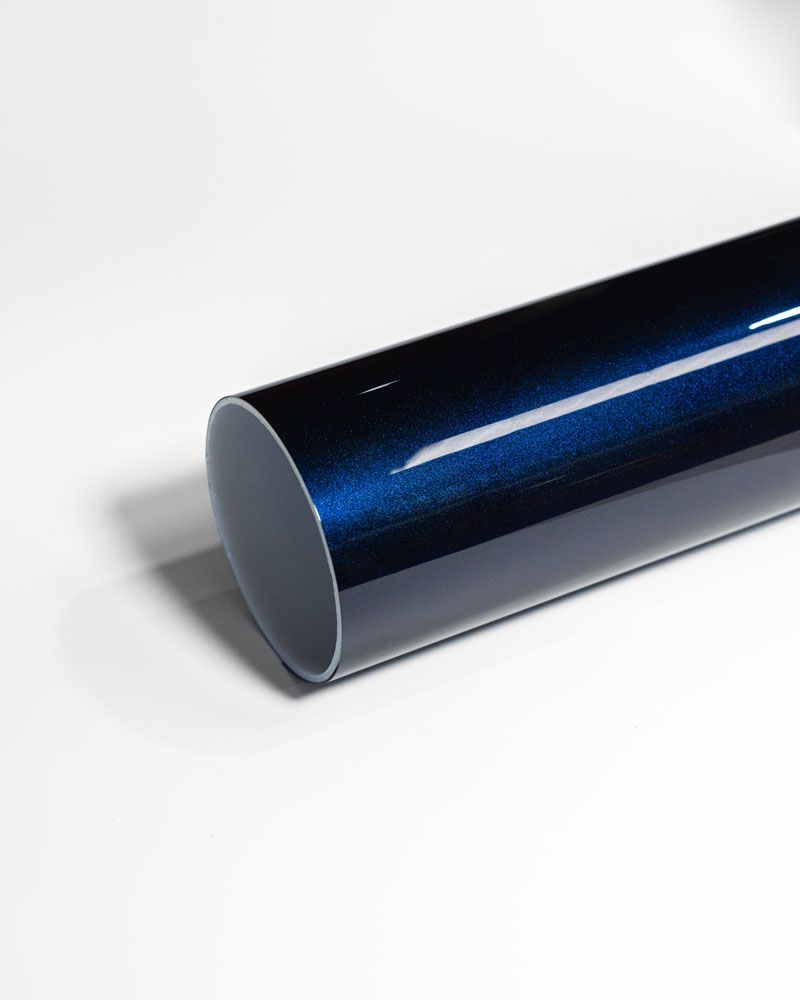 A roll of blue vinyl wrap is sitting on a white surface.