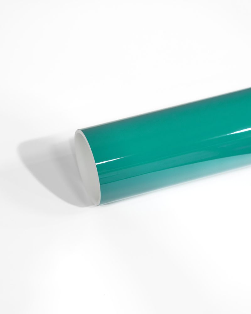 A roll of green vinyl wrap is sitting on a white surface.