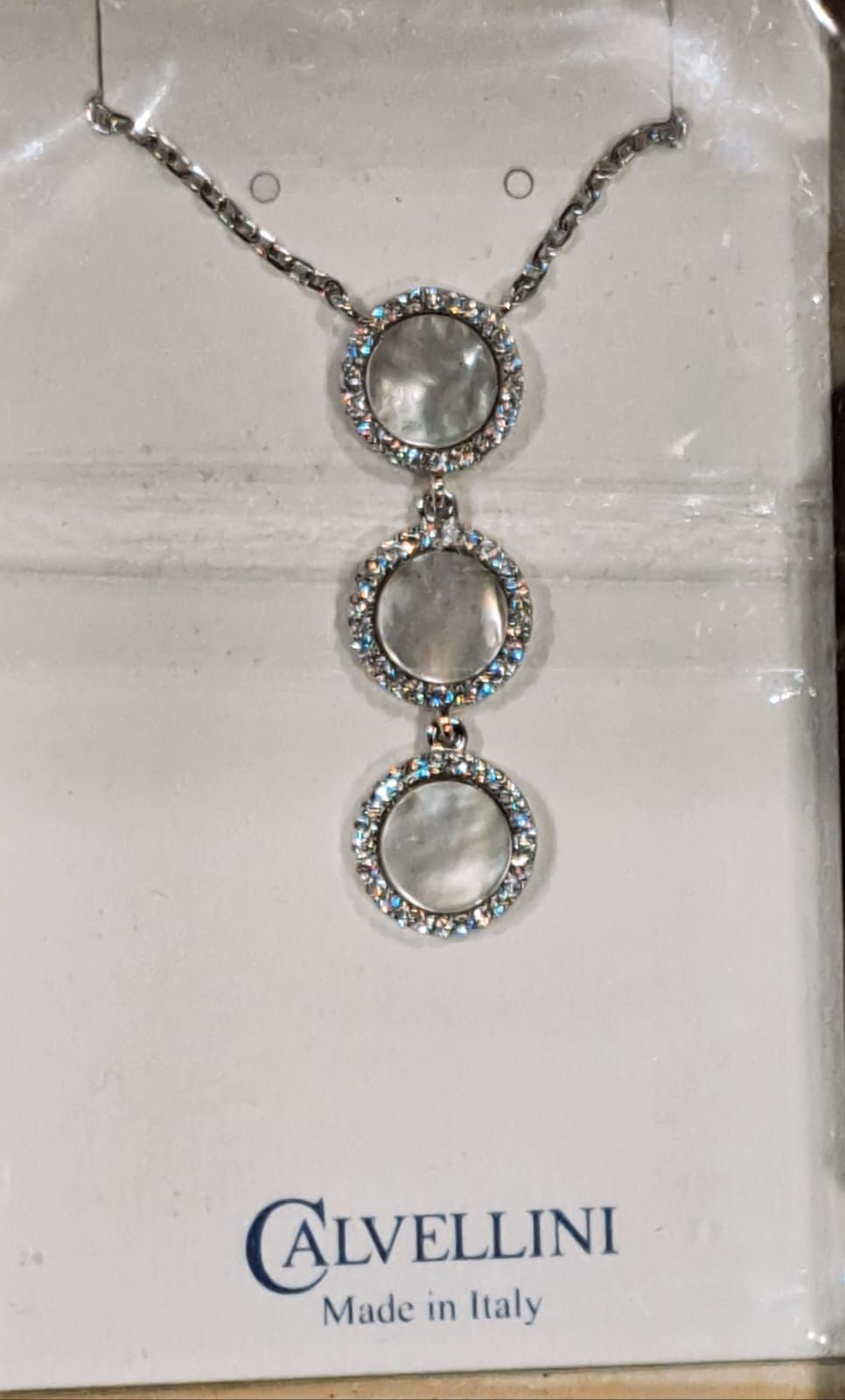 Collana in argento con tre pendenti circolari in cristallo collegati tra loro, su un cartoncino Calvellini.