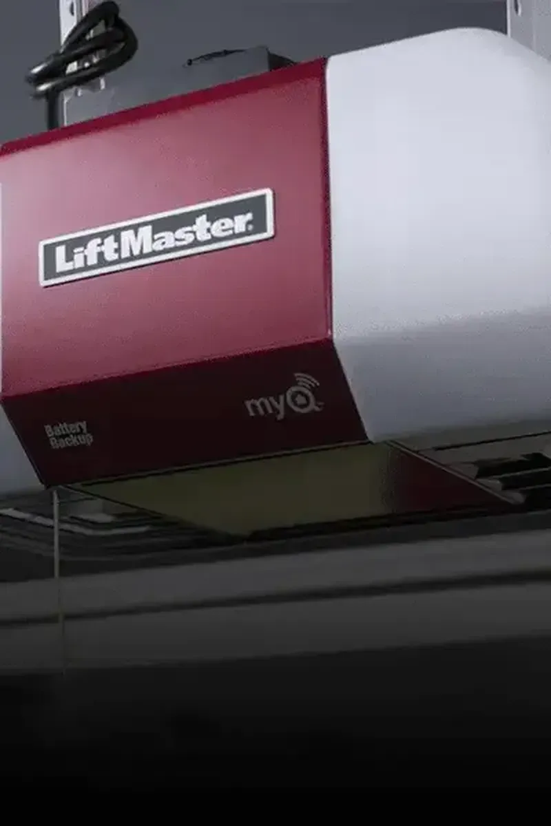 A burgundy and white LiftMaster garage door opener mounted on a ceiling.