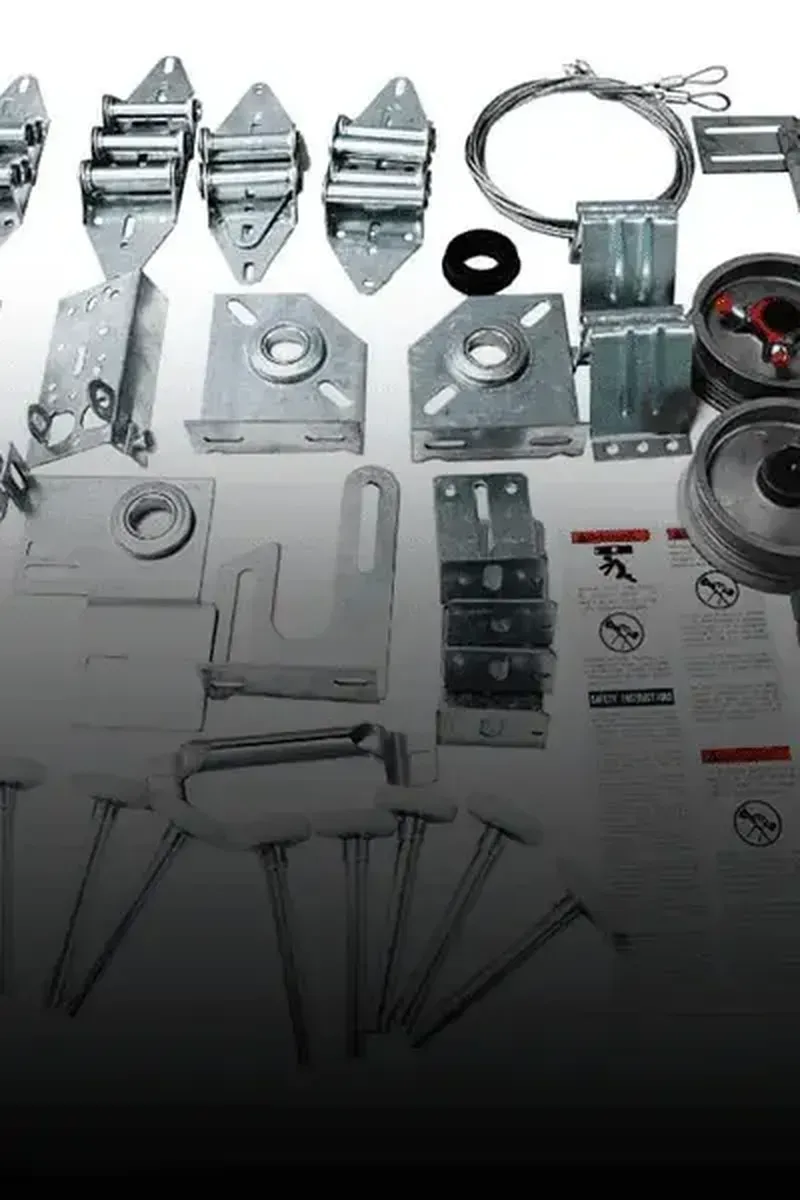 A collection of metal garage door hardware components, including hinges, pulleys, cables, brackets, and bolts.